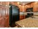 View of kitchen with black appliances and ample wood cabinets at 5450 E Deer Valley Dr # 4201, Phoenix, AZ 85054
