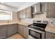 Renovated kitchen featuring gray cabinets, stainless steel appliances, and a tile backsplash at 6249 S Parkside Dr, Tempe, AZ 85283