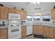 Well-equipped kitchen featuring wood cabinets, updated appliances, and stylish flooring at 8500 E Southern Ave # 538, Mesa, AZ 85209