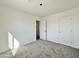 Bright bedroom with neutral carpeting and ample closet space at 10073 W Mission Dr, Arizona City, AZ 85123