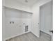 Bright laundry room with overhead shelving and flooring at 10073 W Mission Dr, Arizona City, AZ 85123