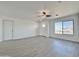 Spacious living room with gray flooring, and view to front door and window at 10073 W Mission Dr, Arizona City, AZ 85123