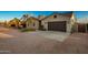 Tan two-story house with a three-car garage and desert landscaping at 10283 E Fortuna Ave, Gold Canyon, AZ 85118