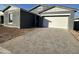 Gray exterior house with white garage door and a brick paved driveway at 11446 E Utah Ave, Mesa, AZ 85212