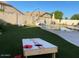 Landscaped backyard with cornhole and artificial turf at 12803 W Campina Dr, Litchfield Park, AZ 85340