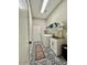 Bright laundry room with tile floor, utility sink, and shelving at 12803 W Campina Dr, Litchfield Park, AZ 85340