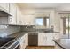 Modern kitchen with white cabinets, gray tile backsplash, and stainless steel appliances at 14614 N 153Rd Ct, Surprise, AZ 85379