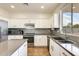 Modern kitchen featuring white cabinets, gray tile backsplash, and stainless steel appliances at 14614 N 153Rd Ct, Surprise, AZ 85379