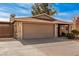 Tan house with a two-car garage and gated driveway at 1511 W El Monte Pl, Chandler, AZ 85224