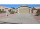 Tan house with a two-car garage and nicely landscaped yard at 15350 W Mauna Loa Ln, Surprise, AZ 85379