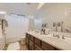 Clean bathroom with double vanity, large mirror, and shower/tub combo at 15526 W Minnezona Ave, Goodyear, AZ 85395