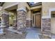 Front entrance with stone columns and a wooden door at 15526 W Minnezona Ave, Goodyear, AZ 85395