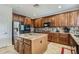 Island kitchen with granite countertops and stainless steel appliances at 15526 W Minnezona Ave, Goodyear, AZ 85395