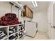 Laundry room with washer, dryer, and ample storage shelving at 15526 W Minnezona Ave, Goodyear, AZ 85395