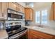 Stainless steel appliances and light wood cabinets in this galley kitchen at 17200 W Bell Rd # 1165, Surprise, AZ 85374