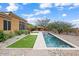 Private rectangular pool with artificial turf and stone patio at 1731 W Steinway Dr, Phoenix, AZ 85041