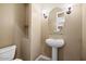 Stylish powder room with pedestal sink and oval mirror at 1731 W Steinway Dr, Phoenix, AZ 85041