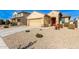 Tan house with a two-car garage and desert landscaping at 17662 W Daley Ln, Surprise, AZ 85387