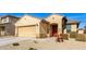 Tan house with a two-car garage and red door at 17662 W Daley Ln, Surprise, AZ 85387