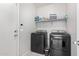 Bright laundry room features washer, dryer, and shelving at 17662 W Daley Ln, Surprise, AZ 85387