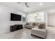 Bright living room featuring a sectional sofa and large TV at 17662 W Daley Ln, Surprise, AZ 85387