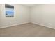 Bright bedroom featuring a large window, neutral carpet, and light gray walls, offering a comfortable living space at 17755 W Elm St, Goodyear, AZ 85395