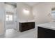 Bathroom with dark vanity, double sinks, and view of bedroom at 18104 W Silverwood Dr, Goodyear, AZ 85338