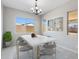 Elegant dining room with marble table, chandelier lighting, and large windows for natural light at 18104 W Silverwood Dr, Goodyear, AZ 85338