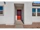 Modern front door with a red wood finish and a covered entryway at 18104 W Silverwood Dr, Goodyear, AZ 85338