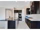 Spacious kitchen with dark cabinetry, granite countertops, and stainless steel appliances at 18104 W Silverwood Dr, Goodyear, AZ 85338