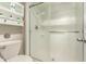 A bathroom with a toilet, shelving unit with decor, and glass-door shower at 1833 W Citrus Way, Phoenix, AZ 85015