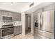 Updated kitchen boasts gray cabinets, stainless steel appliances, stylish backsplash, and a functional layout at 1833 W Citrus Way, Phoenix, AZ 85015