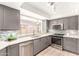 Updated kitchen features gray cabinets, stainless steel appliances, modern backsplash, and quartz countertops at 1833 W Citrus Way, Phoenix, AZ 85015