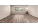 Inviting living room showcasing wood flooring, neutral walls, and bright natural light from a large window at 1833 W Citrus Way, Phoenix, AZ 85015
