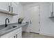 Modern laundry room with gray countertop, white cabinets, and stylish sink at 205 W Blue Ridge Way, Chandler, AZ 85248