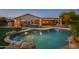 Inviting backyard oasis with a sparkling pool, spa, and covered patio at 21705 N Black Bear Lodge Dr, Surprise, AZ 85387