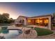 Stunning backyard at dusk with pool, hot tub, and covered patio at 21705 N Black Bear Lodge Dr, Surprise, AZ 85387