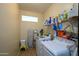 Laundry room with washer, dryer, storage shelves, and ironing board at 21705 N Black Bear Lodge Dr, Surprise, AZ 85387