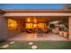 Evening view of covered patio with seating area and lighting at 21705 N Black Bear Lodge Dr, Surprise, AZ 85387