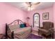 Cozy bedroom features pink walls, a unique arched window, and comfortable seating at 2235 W Villa Rita Dr, Phoenix, AZ 85023