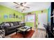 Living room with lime green walls, gray couch, and wood flooring at 2235 W Villa Rita Dr, Phoenix, AZ 85023