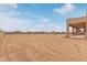 Expansive sandy backyard with partial house view at 22605 W Baker Dr, Wittmann, AZ 85361