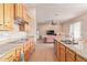 Kitchen with granite countertops and wood cabinets, open to living area at 22605 W Baker Dr, Wittmann, AZ 85361