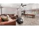 Living room with pool table, brown leather sectional, and open kitchen view at 27511 N 33Rd Ave, Phoenix, AZ 85083