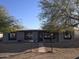 House features a gray exterior, walkway, and mature trees at 303 W 13Th St, Eloy, AZ 85131