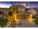 Two-story house with a three-car garage at dusk at 3180 S Greythorne Way, Chandler, AZ 85248