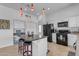 Bright kitchen with white cabinets, an island, and black appliances at 3180 S Greythorne Way, Chandler, AZ 85248