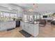 Kitchen with island, white cabinets, and view to living room at 3180 S Greythorne Way, Chandler, AZ 85248