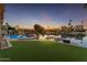 Backyard oasis with a pool and lake view at sunset at 3180 S Greythorne Way, Chandler, AZ 85248