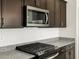 Close up on the stainless steel microwave, granite countertop, and gas range top in the kitchen at 3403 E Audrey Dr, San Tan Valley, AZ 85143